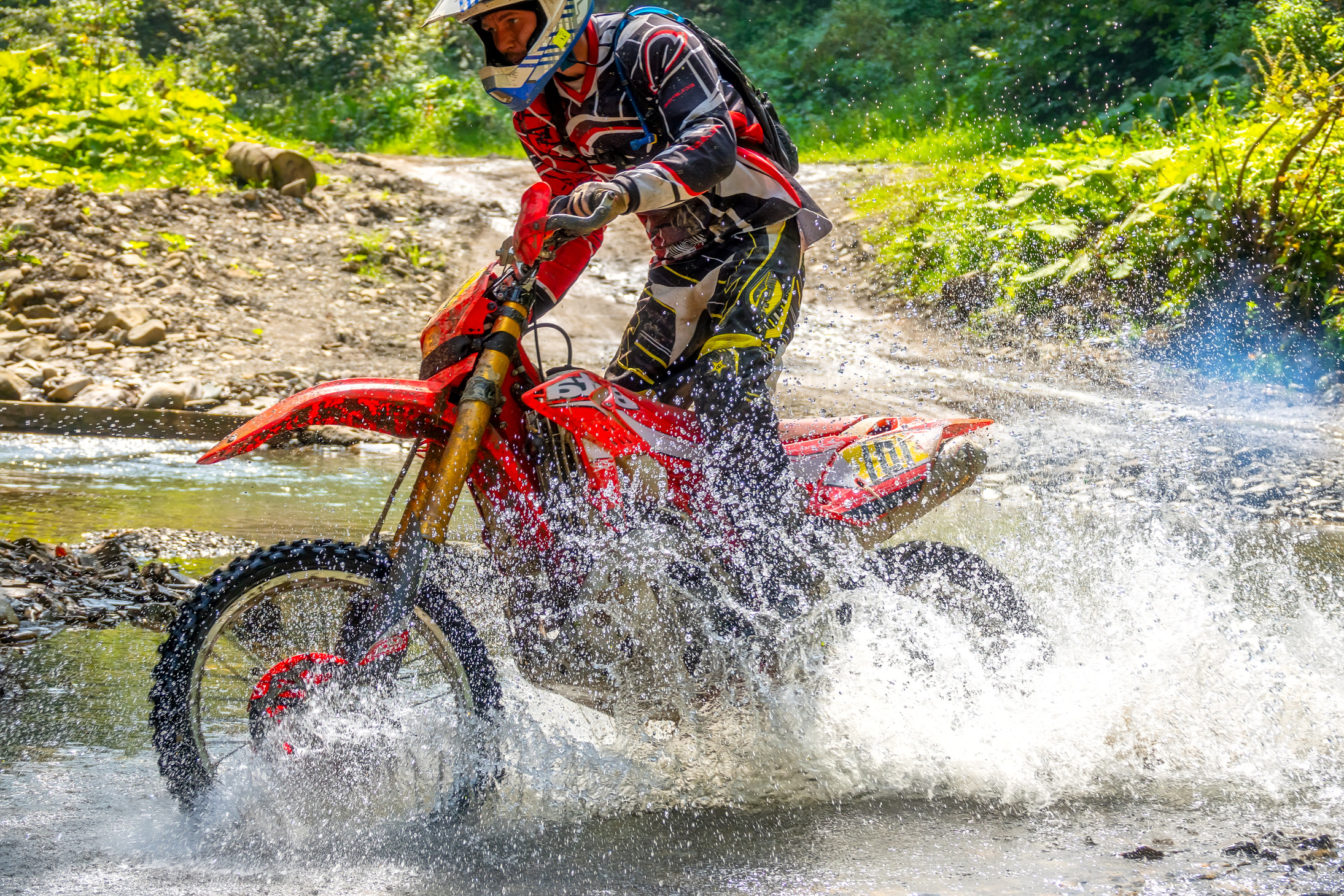 Motorcycle Enduro and Athlete in Water Spray
